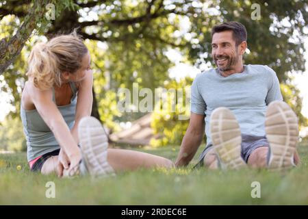 jeune couple faisant de l'exercice dans le parc faisant des étirements Banque D'Images