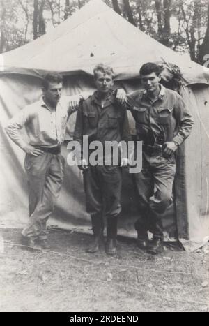 groupe vintage de soldats photo de la seconde guerre mondiale ( ww2) peut-être était-ce une unité qui sont debout ensemble devant la tente blanche. Mission Afrique ? Banque D'Images