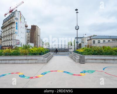 Paris, France - 12 mai 2023 : un pont ferroviaire et un bel endroit et jardin : la place Jan Karski. Banque D'Images