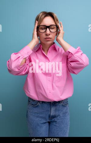 concentré jeune femme chef carriériste blonde réussie en chemisier rose et lunettes Banque D'Images