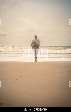 Femme sur la plage au soleil du soir, Zandvoort, pays-Bas Banque D'Images