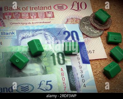 Frais d'hébergement (achat ou location) en Irlande du Nord, billets Sterling, pièces de monnaie, maisons monopolistiques Banque D'Images