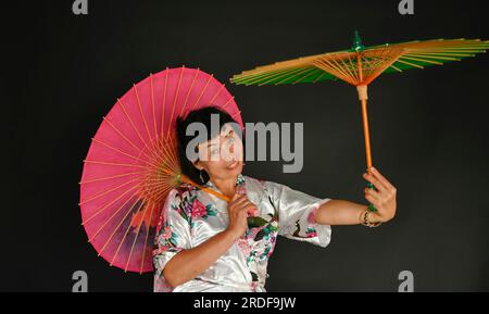 Danse asiatique avec parapluies Banque D'Images