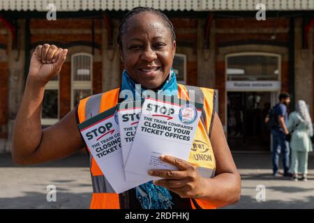 Slough, Royaume-Uni. 21 juillet 2023. Un membre du RMT se tient à l'extérieur de la billetterie de la gare de Slough avec des dépliants pour soutenir la campagne du syndicat Save Our Railway Ticket Offices. Le RMT s'oppose aux plans du gouvernement de fermer les guichets ferroviaires au motif que l'accès des passagers aux billets de meilleure valeur sera restreint, que le service aux passagers, l'accessibilité, la sûreté et la sécurité seront réduits et qu'ils conduiront au démantèlement des gares ferroviaires. Crédit : Mark Kerrison/Alamy Live News Banque D'Images