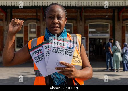 Slough, Royaume-Uni. 21 juillet 2023. Un membre du RMT se tient à l'extérieur de la billetterie de la gare de Slough avec des dépliants pour soutenir la campagne du syndicat Save Our Railway Ticket Offices. Le RMT s'oppose aux plans du gouvernement de fermer les guichets ferroviaires au motif que l'accès des passagers aux billets de meilleure valeur sera restreint, que le service aux passagers, l'accessibilité, la sûreté et la sécurité seront réduits et qu'ils conduiront au démantèlement des gares ferroviaires. Crédit : Mark Kerrison/Alamy Live News Banque D'Images