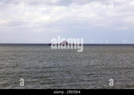 L'extrémité isolée de la jetée de Herne Bay, avec le parc éolien offshore de Kentish Flats derrière elle et Shivering Sands Maunsell Army Sea fort sur la droite Banque D'Images