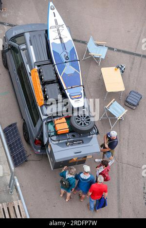 21 juillet 2023, Saxe-Anhalt, Gräfenhainichen : les visiteurs discutent dans un camping-bus VW au festival 'Vanlife-Ferropolis'. Des ateliers et des conférences sont prévus dans la région jusqu'à dimanche (21.07.). En outre, plus de 40 exposants présenteront les dernières innovations en caravaning, offroad, camping et vanlife lors d’un salon. Photo : Jan Woitas/dpa Banque D'Images