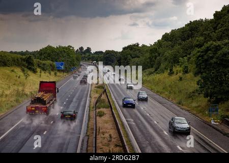 Voitures et camions sur une autoroute mouillée sous la pluie avec des projections s'élevant des roues du véhicule. A1(M) Doncaster, South Yorkshire. Banque D'Images