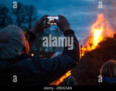 FEUX DE JOIE WALPURGIS en Suède les spectateurs prennent des photos de l'incendie avec leurs téléphones portables Banque D'Images