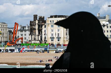 Brighton Royaume-Uni 21 juillet 2023 - Une vue de Brighton Palace Pier découpé comme front de mer et plage de Brighton sont occupés par le Royal Albion Hôtel brûlé sur une journée de soleil et de nuages : crédit Simon Dack / Alamy Live News Banque D'Images