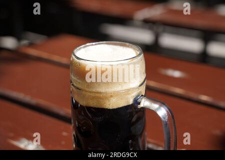 Bière brune dans une tasse à bière. Bière tchèque sur la table du bar restaurant pub à Prague, République tchèque. Banque D'Images