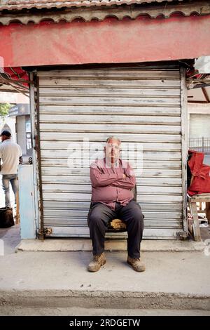 Homme assis sur le siège dans la rue, Amman, Jordanie Banque D'Images