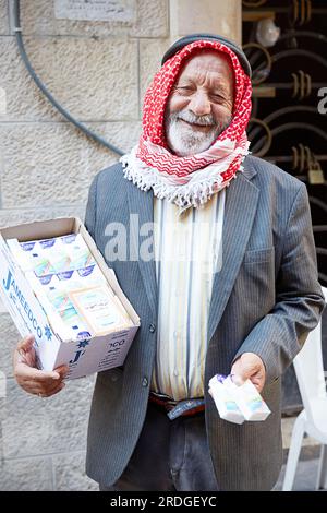 Portrait d'un vieil homme jordanien portant un keffiyeh vendant des mouchoirs dans la rue, Amman, Jordanie Banque D'Images