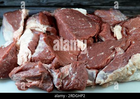 Pile de viande rouge de bœuf fraîche hachée en morceaux prête à être cuite et bouillie dans une eau chaude pour faire de la soupe de viande fraîche ou cuite dans diverses cuisines, sele Banque D'Images