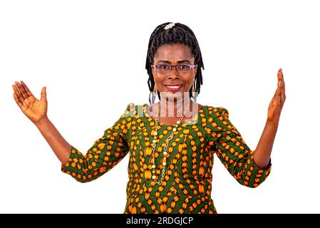 une belle femme d'affaires mature en tenue traditionnelle debout sur fond blanc montrant plus de taille et regardant la caméra souriante. Banque D'Images