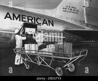 États-Unis : c. 1946 les bagagistes chargent des bagages sur un DC-3 d'American Airlines, le 'Flagship Detroit'. Banque D'Images