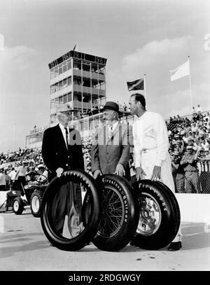 Indianapolis, Indiana : mai 1961 trois générations de pilotes de voitures de course Indy 500 et les pneus Firestone qu'ils ont conduits sur la pose au 50e anniversaire de la course. De gauche à droite : Ray Harroun, vainqueur du premier Indy 500 en 1911 ; Peter de Paolo, vainqueur de l’épreuve 1925 et premier à atteindre une moyenne de plus de 100 km/h pour la course, ainsi que le premier pilote à gagner en utilisant des pneus ballons basse pression; Et Eddie Sachs, vainqueur de la pole position pour la deuxième année consécutive. Banque D'Images