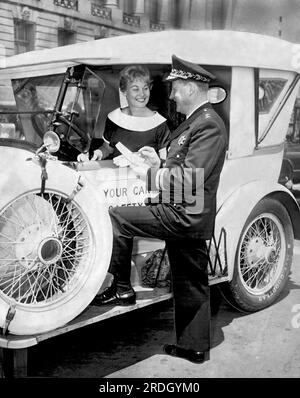 San Francisco, Californie : mai, 1960 le chef de la police de San Francisco Tom Cahill effectue un contrôle de sécurité sur une vieille voiture avec un joli conducteur. Banque D'Images