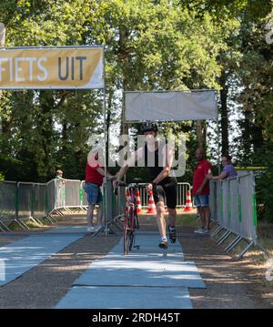 Voorst, pays-Bas - 25 juin 2023 : le participant au triathlon Voorster entre dans la zone de transition après avoir terminé la section cyclisme o Banque D'Images