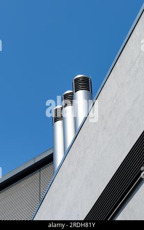 Villach, Autriche. 18 juillet 2023. des cheminées en acier dépassent d'un bâtiment industriel Banque D'Images