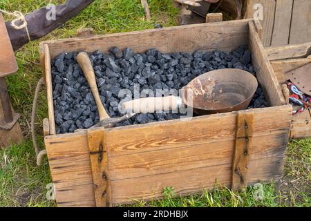 Charbon stocké dans un coffre en bois avec des outils dans une forge Banque D'Images