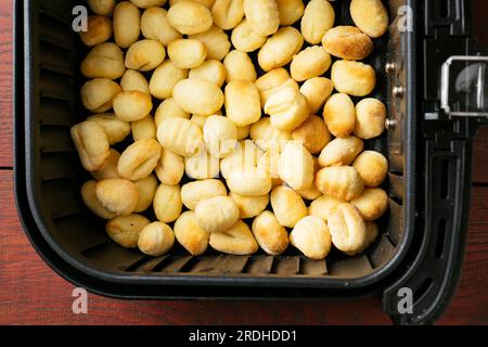 Gnocchi dans un panier de friteuse pneumatique. Banque D'Images