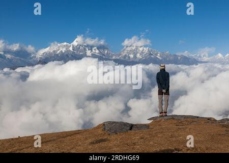 Paysage de solitude dans les hautes montagnes de l'Himalaya au Népal. Voyageur seul debout sur le bord de la falaise regardant les sommets enneigés lointains Banque D'Images