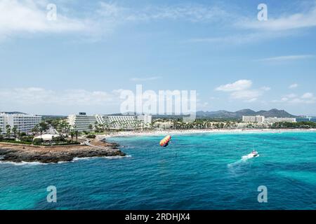 Touristes profitant du parachute ascensionnel sur la plage de sa Coma à Majorque, en Espagne un jour d'été Banque D'Images