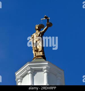 Statue en bronze représentant une femme tenant une échelle et une épée au palais de justice en Caroline du Nord. Figurine de cadres de ciel bleu vif. Banque D'Images