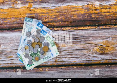 Pile de pièces mexicaines et billets sur la table en bois. Banque D'Images