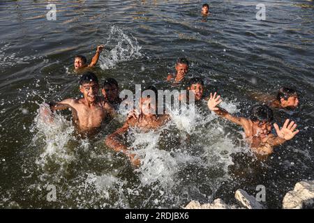 Gizeh, Égypte. 21 juillet 2023. Les garçons se refroidissent dans un canal pendant une canicule à Gizeh, en Égypte, le 21 juillet 2023. Crédit : Ahmed Gomaa/Xinhua/Alamy Live News Banque D'Images