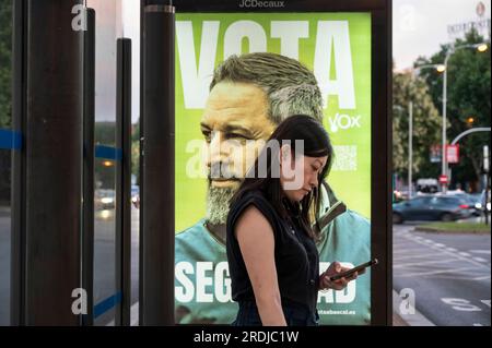 Madrid, Espagne. 22 juillet 2023. Une femme se tient debout à un arrêt de bus alors qu'une publicité du parti conservateur et d'extrême droite VOX, présentant le politicien espagnol Santiago Abascal comme candidat aux prochaines élections générales espagnoles, apparaît en arrière-plan. Crédit : SOPA Images Limited/Alamy Live News Banque D'Images