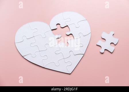 Coeur de puzzle blanc avec pièce manquante à l'extérieur. Banque D'Images