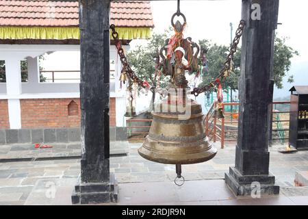 Vue rapprochée d'une cloche de temple faite de matériau de bronze, accrochée entre deux piliers Banque D'Images