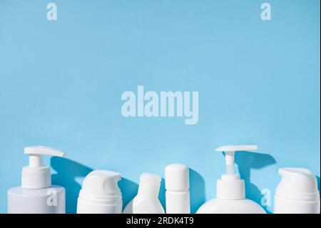 Nature morte. Pose à plat. Assortiment de petits flacons blancs de maquette de testeur pour l'emballage et le design de marque, avec des produits cosmétiques de beauté disposés, isolés Banque D'Images