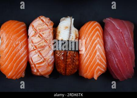 Cuisine traditionnelle japonaise - ensemble de sushis Nigiri garnis de saké (saumon), Maguro (thon), Unagi (anguille d'eau douce) Banque D'Images