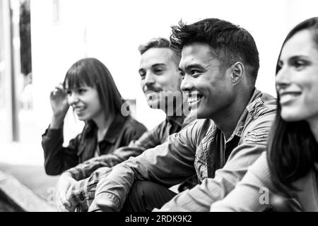 Groupe de personnes multiculturel sans smartphone dans la cour de l'université - heureux amis du millénaire s'amuser ensemble assis dans la rue - Banque D'Images