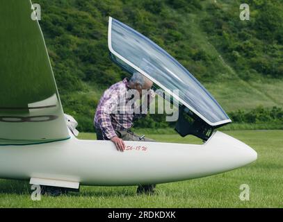 Un homme vérifie les cadrans et l'état de son avion Glider sur une piste d'atterrissage en Angleterre au Royaume-Uni Banque D'Images