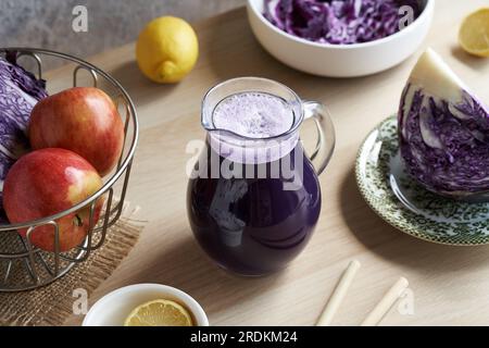 Jus de chou violet dans une cruche en verre avec des pailles de bambou Banque D'Images