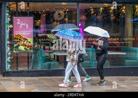 Preston Lancashire. UK Météo 22 juillet 2023. Soldes d'été, magasins et acheteurs par jour de pluie dans le centre-ville. Les prévisionnistes disent: "La pluie, parfois lourde, jusqu'au samedi et dimanche est susceptible de causer des perturbations, en particulier pour les événements extérieurs. Crédit : MediaWorldImages/AlamyLiveNews Banque D'Images