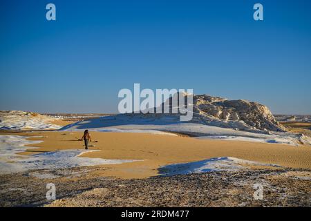 13 avril 2023, QSAR El Farafra, Egypte : un homme vu marchant dans le désert blanc, Egypte. De l'érosion des volcans et d'une montagne de quartz, aux roches altérées et aux formations rocheuses de craie blanche, Black and White Desert fait partie de la dépression de Frarafra dans le désert du Sahara et se situe dans la partie occidentale de l'Égypte. Le vaste désert est relié aux routes principales qui sont proches de la frontière libyo-égyptienne où il est maintenant lourdement armé avec une présence militaire. Le paysage naturel bizarre qui s'élève d'un fond océanique il y a des millions d'années est maintenant laissé avec des formations karstiques calcaires qui ressemblent à la surface d'Othe Banque D'Images