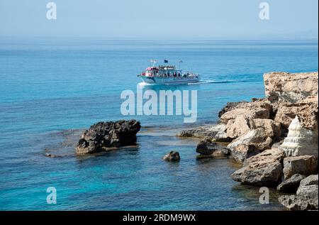 Yacht touristique naviguant dans la mer avec des touristes profitant des vacances d'été et faisant du tourisme. Péninsule d'Akamas Chypre Banque D'Images