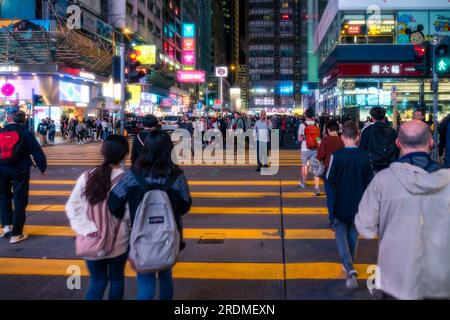 Hong Kong,25 mars 2019:les gens parmi les gratte-ciel à travers les rues de Hong Kong pendant une nuit Banque D'Images