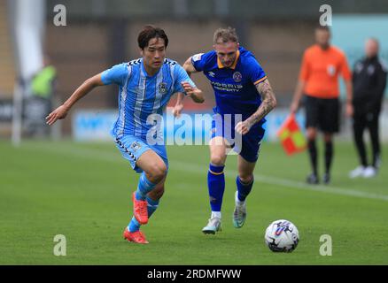 Tatsuhiro Sakamoto de Coventry City (à gauche) et Carl Winchester de Shrewsbury Town en action lors du match amical de pré-saison au croud Meadow, Shrewsbury. Date de la photo : Samedi 22 juillet 2023. Banque D'Images