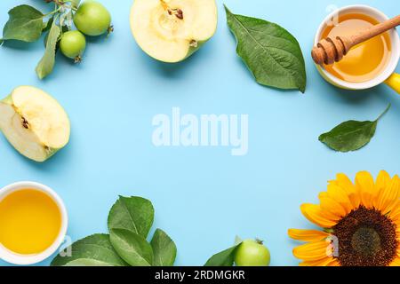 Cadre fait de bols avec du miel, du tournesol et des pommes pour la célébration de Rosh Hashanah (nouvel an juif) sur fond bleu Banque D'Images