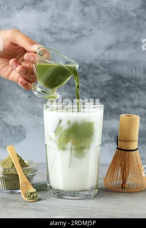 Verser le Matcha vert dans un verre avec du lait et de la glace, Matcha Greentea Latte glacé Banque D'Images