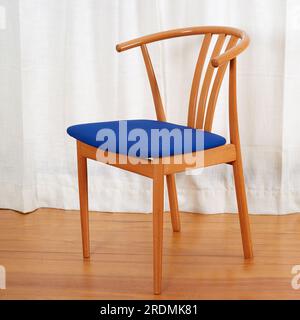 Trois chaises en bois minimalistes modernes du milieu du siècle avec sièges bleus. chaises de style wishbone des années 1960. Banque D'Images