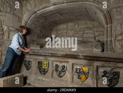 Femme senior regardant de vieilles effigies en pierre usées, Corstorphine Old Parish Church, Édimbourg, Écosse, Royaume-Uni Banque D'Images