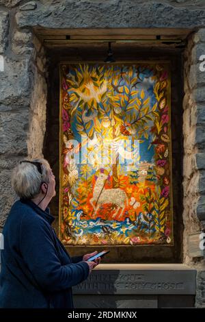Femme senior enregistrant des informations sur les tapisseries murales sur l'application de téléphone mobile, Corstorphine Old Parish Church, Édimbourg, Écosse, Royaume-Uni Banque D'Images