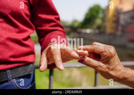 Gros plan femme a n e mettant bague de fian ailles sur le doigt d